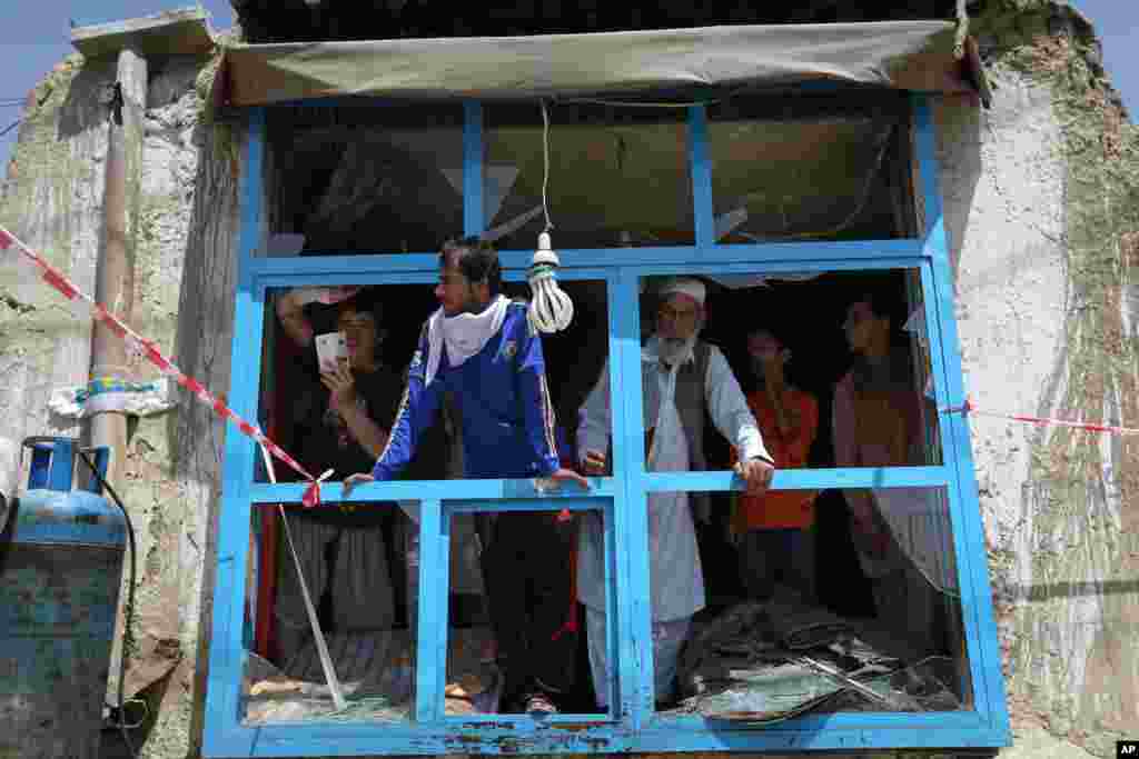People inspect a shop damaged in a suicide attack, Kabul, May 4, 2015.&nbsp;