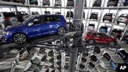 FILE - Volkswagen cars are lifted inside a delivery tower of the company in Wolfsburg, Germany, March 14, 2017. Due to rising demand for German products, the U.S. trade deficit with Germany has nearly doubled in the past 10 years from some 28.8 billion euros in 2006 to 49 billion euros in 2016, according to German data.