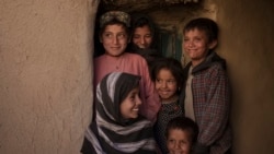 Mina Ahmed's children and relatives laugh as they pose for a photo in their house at Salar village, Wardak province, Afghanistan, Oct. 12, 2021.