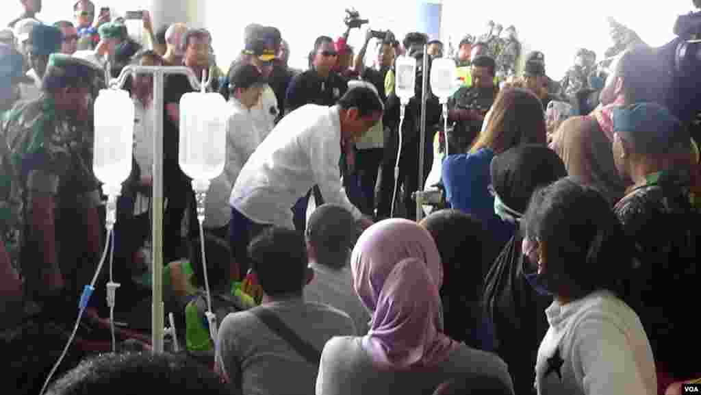 Indonesian President Joko Widodo checks on an earthquake victim being treated at a temporary medical facility set up at the airport in Palu, Sulawesi, Oct. 3, 2018. (Y. Litha/VOA)