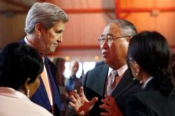 资料照片:时任美国国务卿的克里与中国气候事务代表解振华在法国举行的《巴黎协定》第21届缔约方大会期间交谈。(2015年12月12日)
