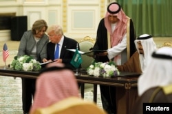 Saudi Arabia's King Salman bin Abdulaziz Al Saud (right) and U.S. President Donald Trump sign a joint security agreement at the Royal Court in Riyadh, Saudi Arabia, May 20, 2017.