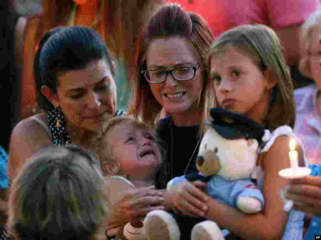 Dechia Gerald, wife of slain Baton Rouge police officer Matthew Gerald, cries while holding their children Fynleigh, left, and Dawclyn, right, at the Healing Place Church in Baton Rouge, Louisiana, July 18, 2016.