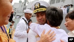FILE - U.S. Navy Cmdr. Michael Vannak Khem Misiewicz embraces an aunt at Sihanoukville, Cambodia, upon his return to his homeland, Dec. 3, 2010. The aunt had helped arrange his adoption in the U.S. Misiewicz now has been sentenced in a bribery scandal.