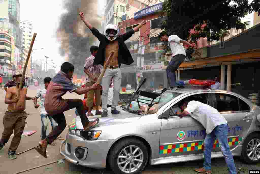 Bangladesh Nationalist Party activists damage a police vehicle during clashes in Dhaka.