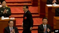 在全国人大开幕式上，中国总理李克强（中）从国家主席习近平（右）身后走上台做报告。（2016年3月5日）