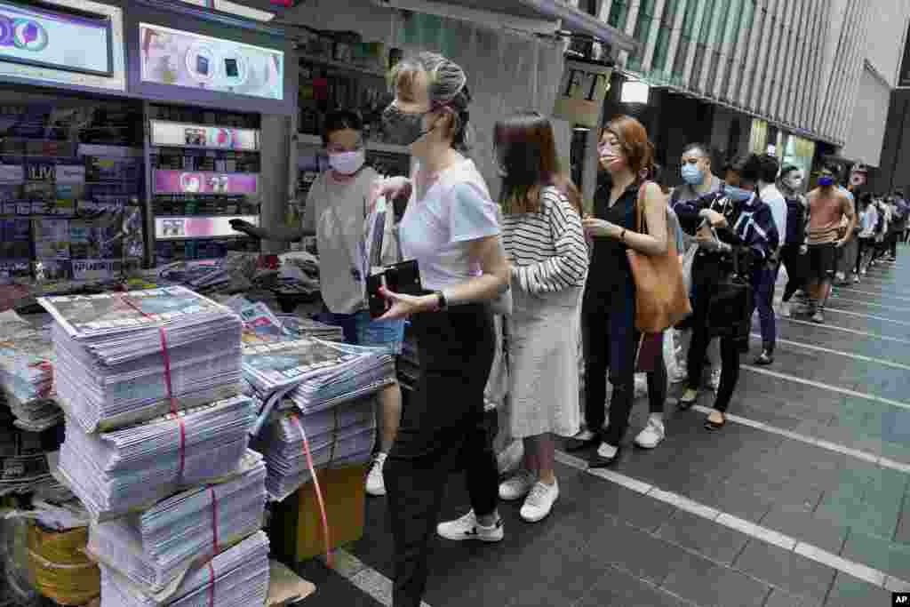 Ljudi čekaju da kupe poslednje izdanje lista Epl Dejli u centru Hong Konga. Poslednje prodemokratske novine prestaće da izlaze nakon prošlonedeljnog hapšenja pet urednika zajedno sa šefom pomenute novinske kompanije vredne 2,3 miliona dolara. Vlasti se pozivaju na nedavno uveden zakon o nacionalnoj bezbednosti. 24. juni, 2021. ( Foto: Vinsent Ju / AP )