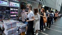 People queue up for last issue of Apple Daily at a newspaper booth at a downtown street in Hong Kong, Thursday, June 24, 2021. (AP)