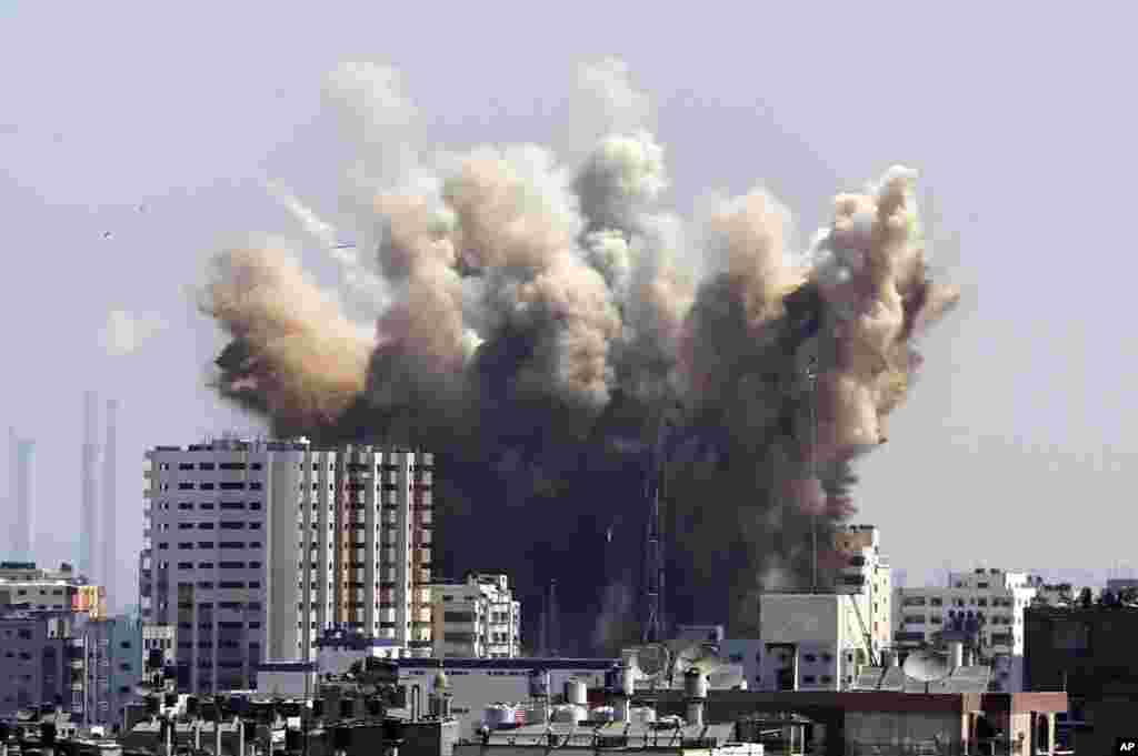 Smoke, dust and debris rise after an Israeli strike, Gaza City , Friday, Aug. 8, 2014