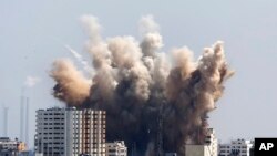 Smoke, dust and debris rise after an Israeli strike, Gaza City , Friday, Aug. 8, 2014