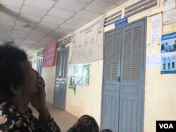A woman sits in front of delivery room at Mesor Thngork health center where Prak Soda delivered her baby and died soon after, in Chantrea district, Svay Rieng province, Feb 8, 2019. (Sun Narin/VOA Khmer)