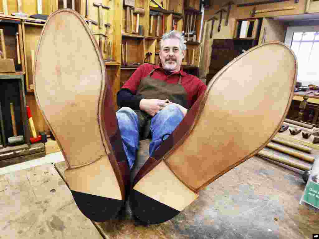 Shoemaker Juergen Dohn poses with shoes he made in 150 hours of work with the size of 75 (US 34) in Frankfurt.
