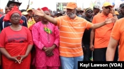 Début de la marche, en T-Shirt et casquette orange tenant sa tête, le chef de file de l'opposition, Jean-Pierre Fabre à Lomé, le 6 septembre 2017. (VOA/Kayi Lawson)