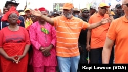 Début de la marche, en T-Shirt et casquette orange tenant sa tête, le chef de file de l'opposition, Jean-Pierre Fabre à Lomé, le 6 septembre 2017. (VOA/Kayi Lawson)