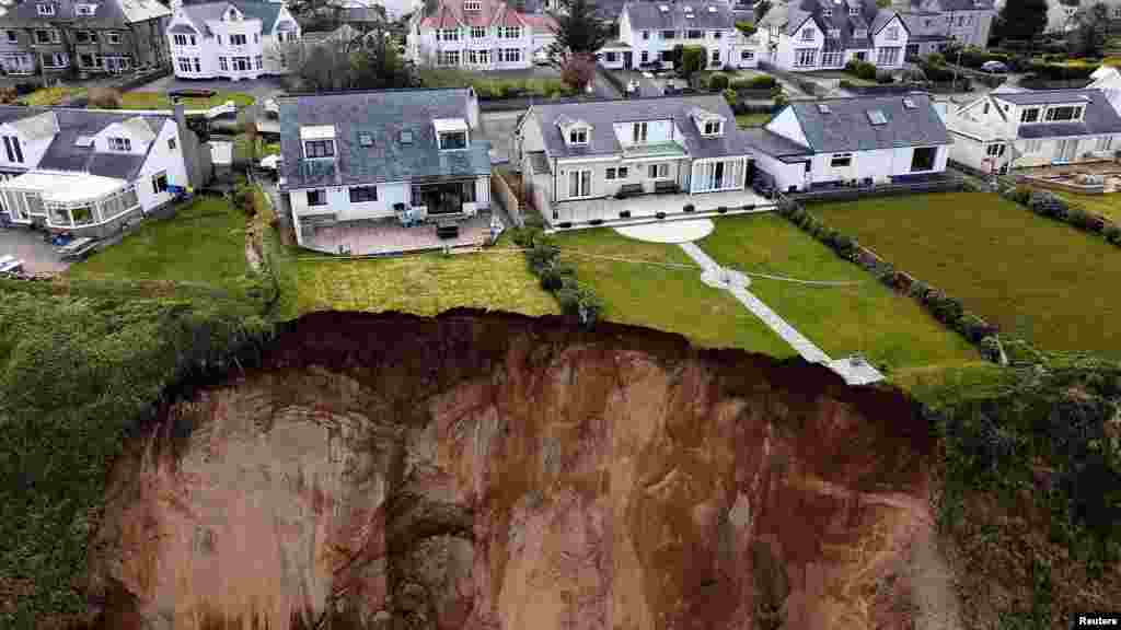 Houses are seen on the edge of a cliff after it collapsed in the village of Nefyn, Wales, Britain.