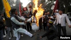 Shi'ite Muslims burn a representation of Saudi King Salman bin Abdulaziz during a protest against the execution in Saudi Arabia of cleric Nimr al-Nimr, in front of Saudi Arabia's embassy in New Delhi, India, Jan. 4, 2016.