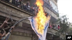 Palestinian mourners burn an Israeli flag during a funeral procession of three Palestinians who killed when Israeli soldiers opened fire on Sunday at protesters at Syria's border with the Israeli-controlled Golan Heights, May 16 2011