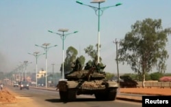 A military tank patrols along one of the main roads in the South Sudanese capital Juba, Dec. 16, 2013. The South Sudanese president declared a curfew in the capital Juba on Monday after clashes overnight between rival factions of soldiers.