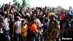 Supporters of Zimbabwean President Robert Mugabe's ZANU-PF party cheer during an election rally in Chitungwiza, about 35 kilometers south of the capital Harare, July 16, 2013.