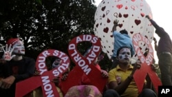 Participants hold placards in the shape of the red ribbon, the universal symbol of awareness and support for those living with HIV, as a hot air balloon is released during an awareness campaign ahead of World AIDS Day in Kolkata, India, Nov. 30, 2018.