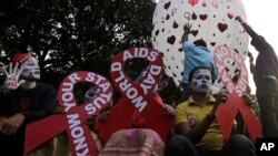 Participants hold placards in the shape of the red ribbon, the universal symbol of awareness and support for those living with HIV, as a hot air balloon is released during an awareness campaign ahead of World AIDS Day in Kolkata, India, Nov. 30, 2018.