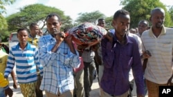 Mourners carry the body of Somali journalist Mohamed Mohamud who was killed after being shot six times by gunmen, Oct. 27, 2013. 