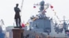 FILE - Chinese destroyer Xian is moored at the Neva River embankment in St.Petersburg, Russia, July 26, 2019, with a sculpture of admiral and explorer Ivan Krusenshtern on the left. 