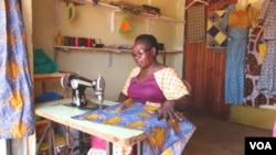 Isidoro Magda makes a dress in her shop at the Kampala suburb of Kisugu, Uganda. Magda says learning how to sew and setting up her own business put her on her way to financial independence. (Simon Peter Apiku/VOA)