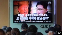 People watch a TV screen showing images of U.S. President Donald Trump, left, and North Korean leader Kim Jong Un during a news program at the Seoul Railway Station in Seoul, South Korea, May 25, 2018. 