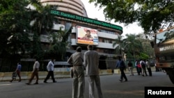 People watch a large screen displaying India's benchmark share index on the facade of the Bombay Stock Exchange (BSE) building in Mumbai, Dec. 9, 2013
