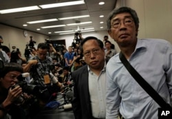Freed Hong Kong bookseller Lam Wing-kee, right, is accompanied by pro-democracy lawyer Albert Ho after giving a news conference in Hong Kong, June 16, 2016.