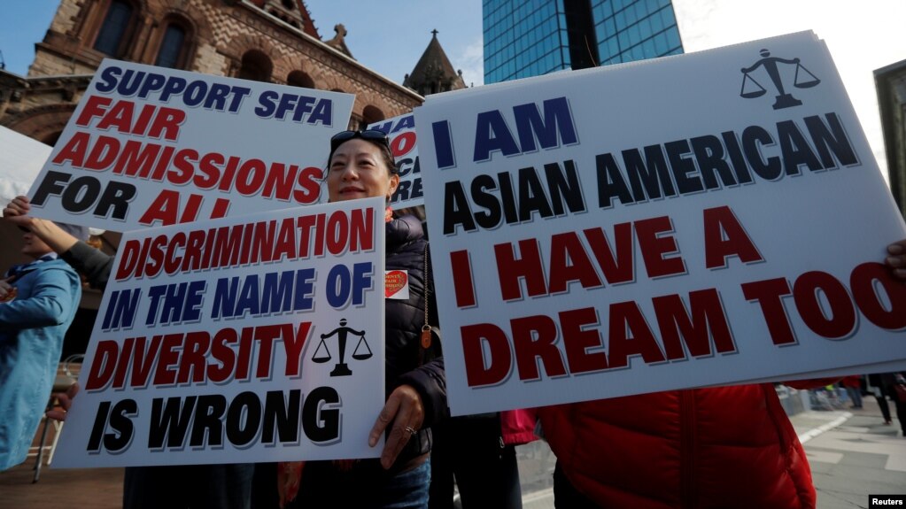 2018年10月14日，法院开始审理亚裔申请者被哈佛大学招生歧视案件前，反对“平权法”人士举牌抗议。（路透社照片）(photo:VOA)