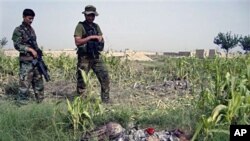 Afghan National Army soldiers stand near bodies of two suicide attackers near a NATO base in Khost province of Afghanistan, 28 Aug 2010