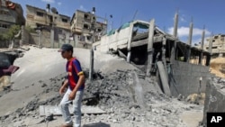 A Palestinian walks on rubble after an Israeli air strike damaged a sports facility belonging to the Islamic Jihad group in Beit Lahiya in the northern Gaza Strip, August 25, 2011