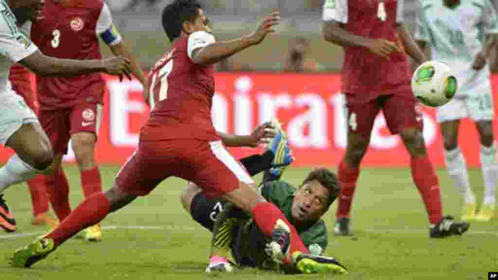 Tahiti goalkeeper Xavier Samin looks on as his teammate Jonathan Tehau, left, scores an own goal to give Nigeria a 4-1 lead.