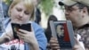 Opposition activists use electronic devices pictured with portraits of prominent anti-corruption blogger Alexei Navalny during a four day-long protest in a boulevard in central Moscow, May 10, 2012.