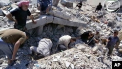 This citizen journalism image provided by Qusair Lens, which has been authenticated based on its contents and other AP reporting, shows Syrian citizens inspecting the rubble of damaged buildings that were damaged from a Syrian forces air strike in the tow