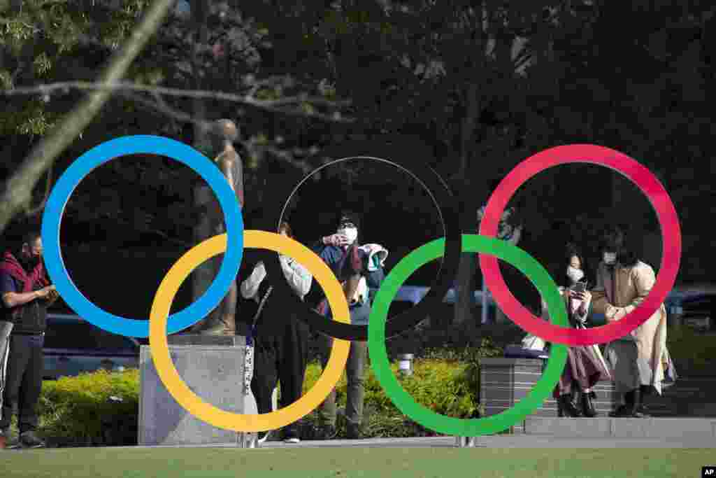 People take pictures of the Olympic rings installed by the Japan Olympic Museum in Tokyo on Friday, March 19, 2021. (AP Photo/Hiro Komae)