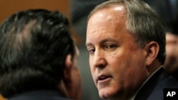 In Texas' lawsuit, state Attorney General Ken Paxton — shown at right during a hearing in McKinney, Texas, on Dec. 1, 2015 — cited security concerns and the alleged failure of the federal government to fully inform Texas about Syrian refugee resettlement plans.