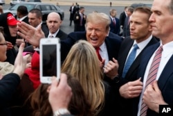 President Donald Trump shakes hands with supporters as he arrives at Allen County Airport, March 20, 2019, in Lima, Ohio.