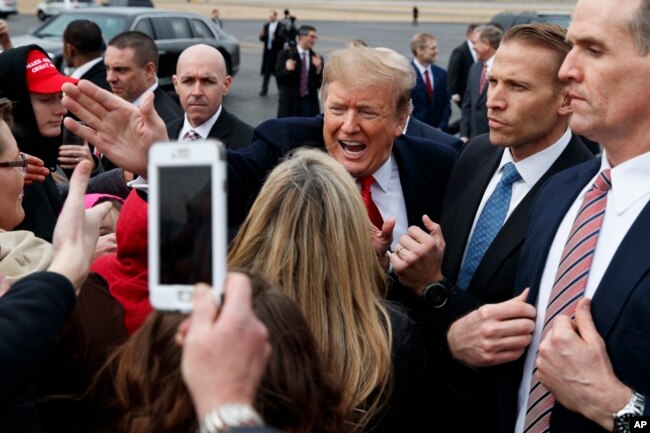 President Donald Trump shakes hands with supporters as he arrives at Allen County Airport, March 20, 2019, in Lima, Ohio.