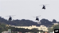 FILE - US military helicopters flying over the US Marine Corps Futenma Air Base in Ginowan, Okinawa Prefecture, Japan.