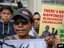 Para aktivis membawa poster-poster saat berdemo untuk menarik perhatian kepada isu HAM Papua, di depan Kedutaan Besar Belanda di Jakarta, di tengah kunjungan Raja Belanda Willem-Alexander, 12 Maret 2020. (Foto: AFP)