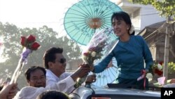 Pro-democracy leader Aung San Suu Kyi receives flowers from supporters on her vehicle during her election campaign trip to Thone-Gwa township in Rangoon, Burma, February 26, 2012.