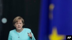 German Chancellor Angela Merkel stands behind a European flag as she waits for the arrival of Chinese President Xi Jinping at the chancellery in Berlin, Germany, Wednesday, July 5, 2017. 