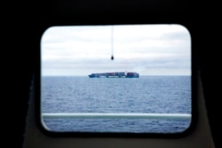 FILE - A China Shipping Line cargo ship sails sails the North Pacific Ocean off the coast of Alaska past the Finnish icebreaker MSV Nordica, July 11, 2017.