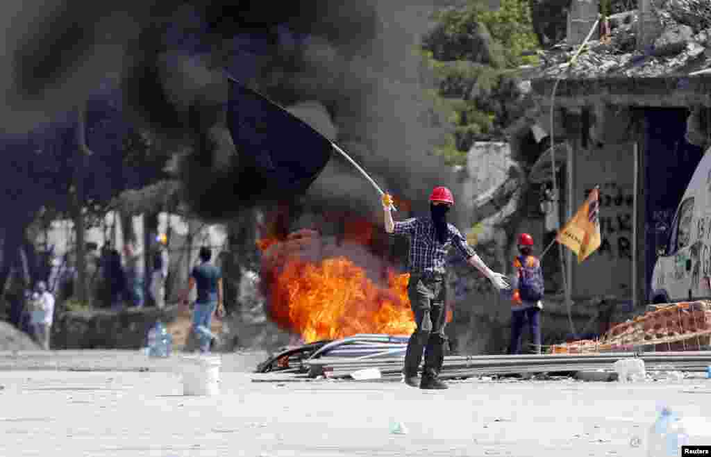 A protester taunts riot police in Taksim Square in Istanbul, June 11, 2013.