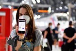 Seorang perempuan menunjukkan Green Pass digital COVID-19 miliknya di stasiun kereta Milan, Italia, 1 September 2021. (REUTERS/Flavio Lo Scalzo)