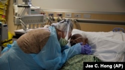 Romelia Navarro, 64, akilia huku amemkumbatia mumewe, Antonio, akiwa mahtuti kutokana na COVID-19 kwenye St. Jude Medical Center in Fullerton, Calif., Ijumaa, Julai 31, 2020.