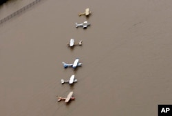 Airplanes sit at a flooded airport near the Addicks Reservoir as floodwaters from Tropical Storm Harvey rise, Aug. 29, 2017, in Houston.